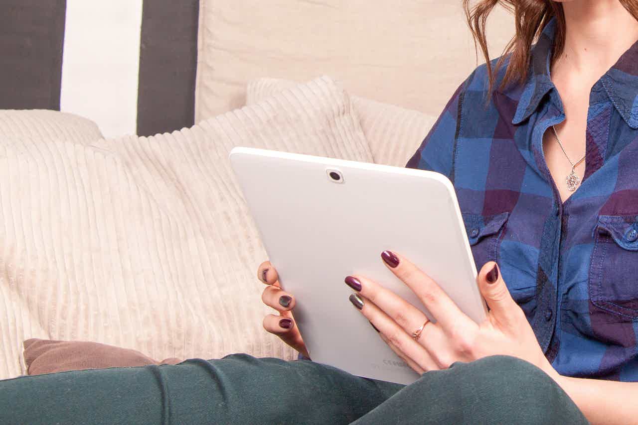 woman in blue plaid shirt using tablet to read R+R blogs