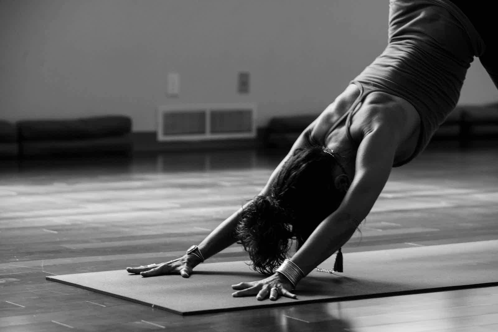 Person lying on a yoga mat in a sunlit room