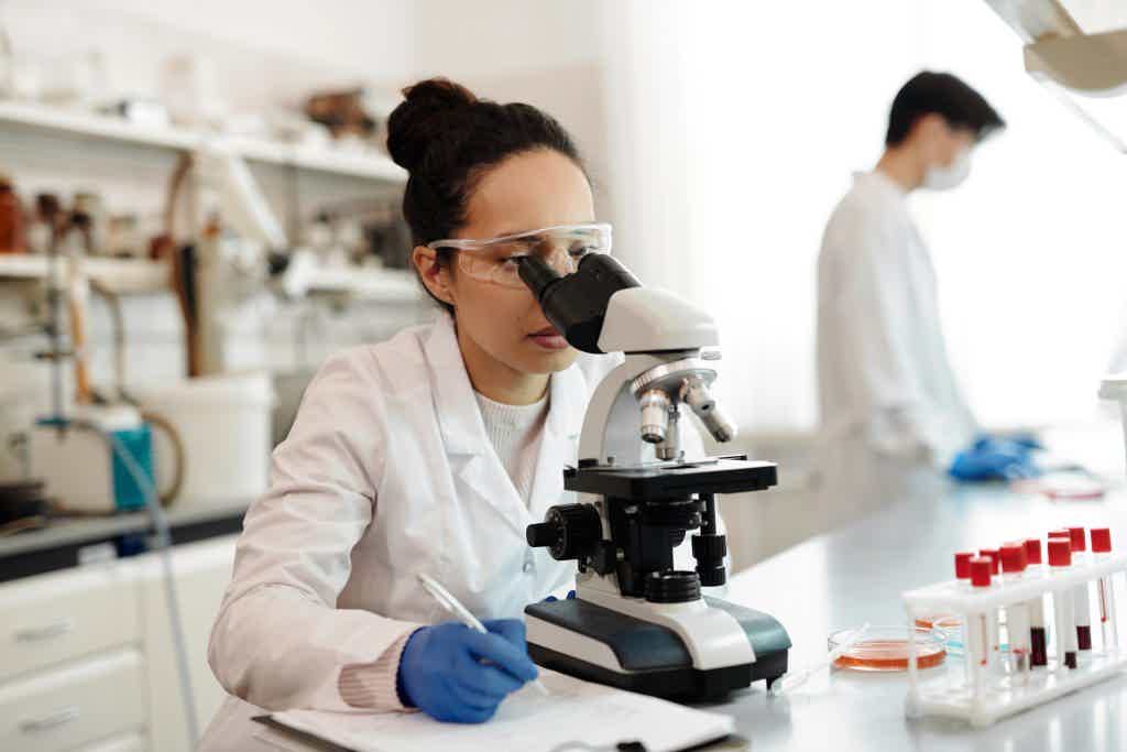 Calgary lab technician analyzing a gut microbiome stool sample under a microscope, part of the GI-MAP testing process.
