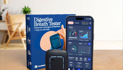 Home breath tester box and smartphone app on a table, showing “Digestive Breath Tester” screen graphics