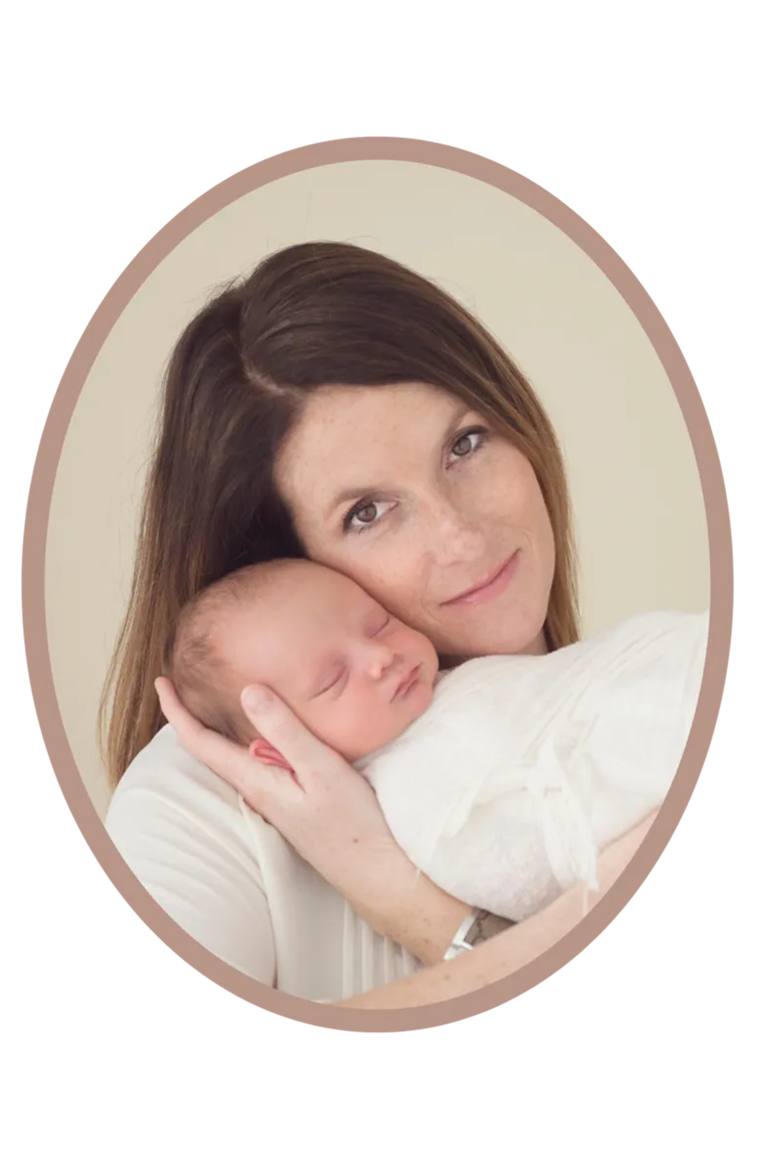 Smiling woman holding a sleeping baby in her arms against a light background.