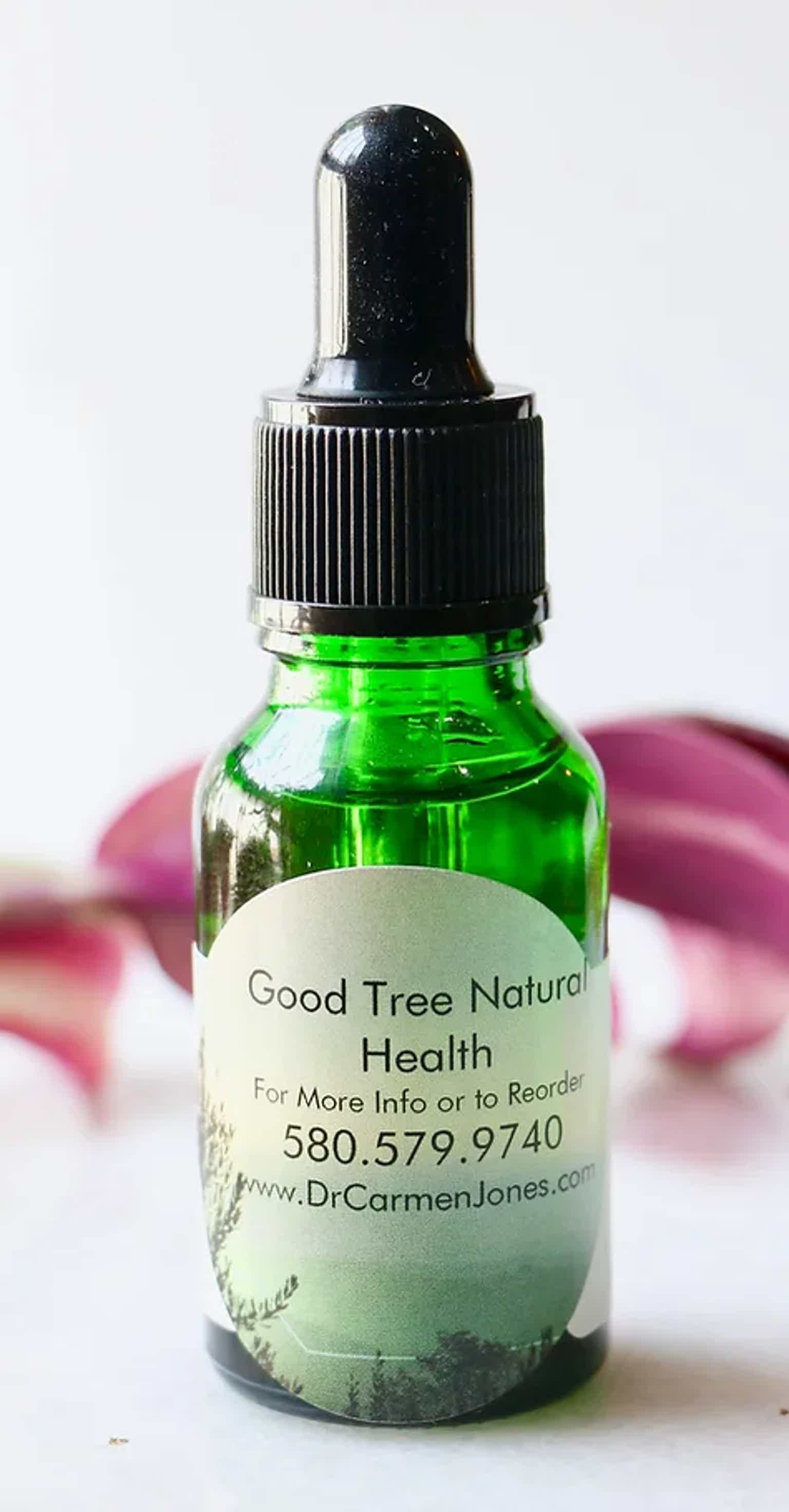 A green glass dropper bottle with a label for