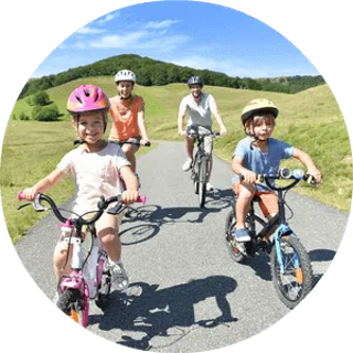 Family of four cycling together on a sunny day in the countryside.