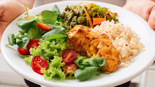 Balanced plate with grilled chicken, brown rice, fresh salad, and sautéed vegetables for steady energy.