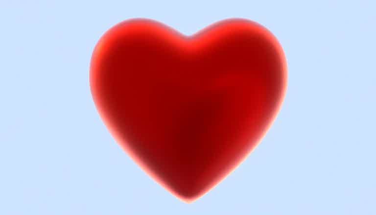 A glossy red heart with a soft glow on a light blue background.