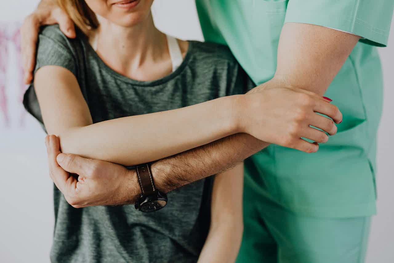 Osteopathic manual therapist pulling arm upwards
