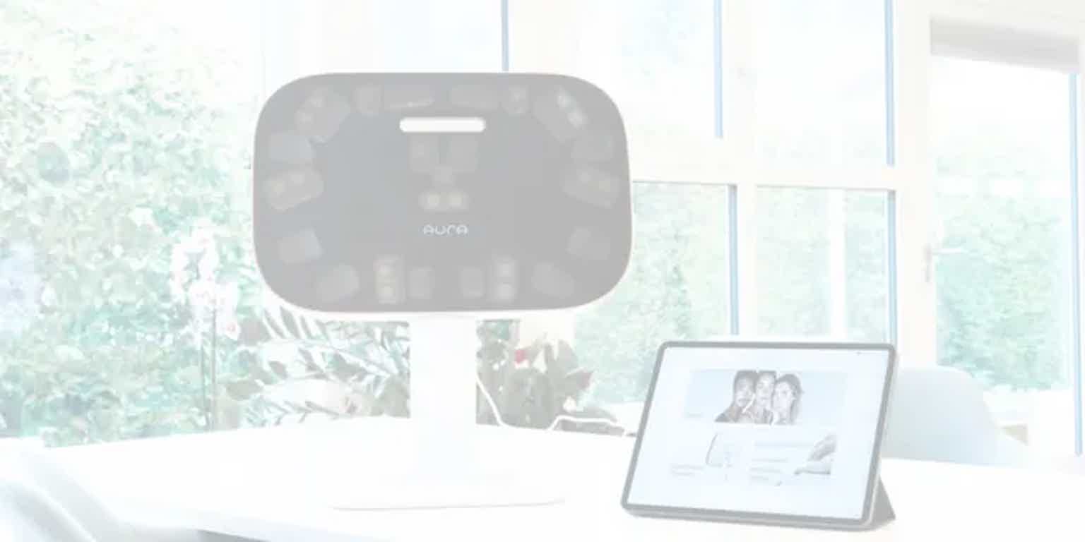 AURA smart scale on a stand in a bright office, with a tablet displaying a screen.