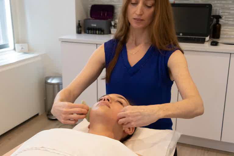 Woman peacefully resting with head on folded towel, after receiving massage therapy.