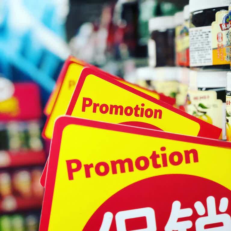 Bright yellow "Promotion" sale signs stacked in a store aisle.