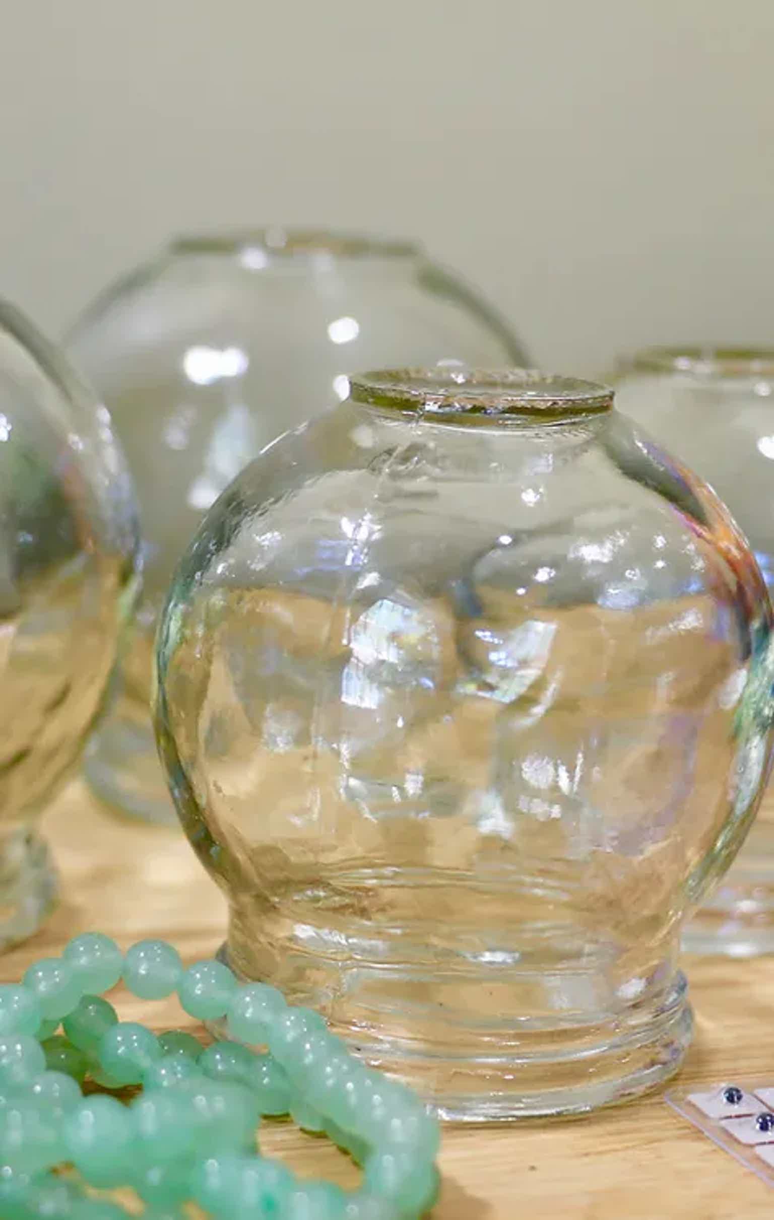 Close-up of clear glass vases on a wooden surface with soft background focus.