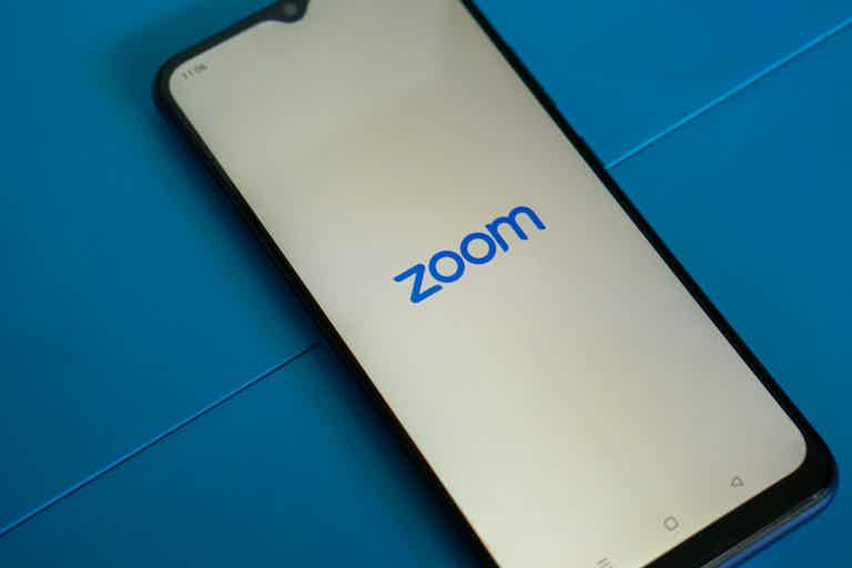 Phone screen displays the Zoom logo on a light gradient background.