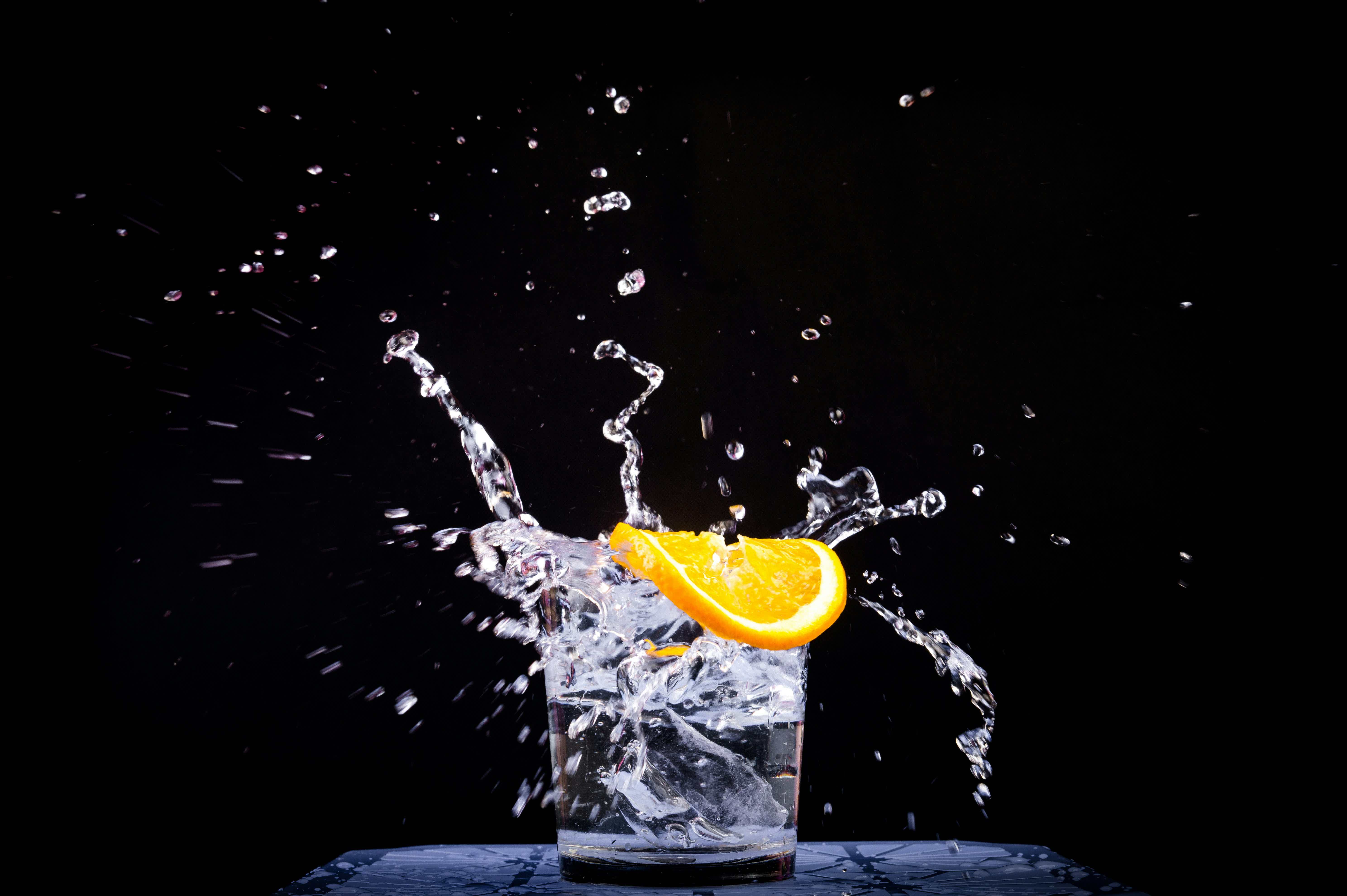 splash of water in drinking glass with sliced lemon